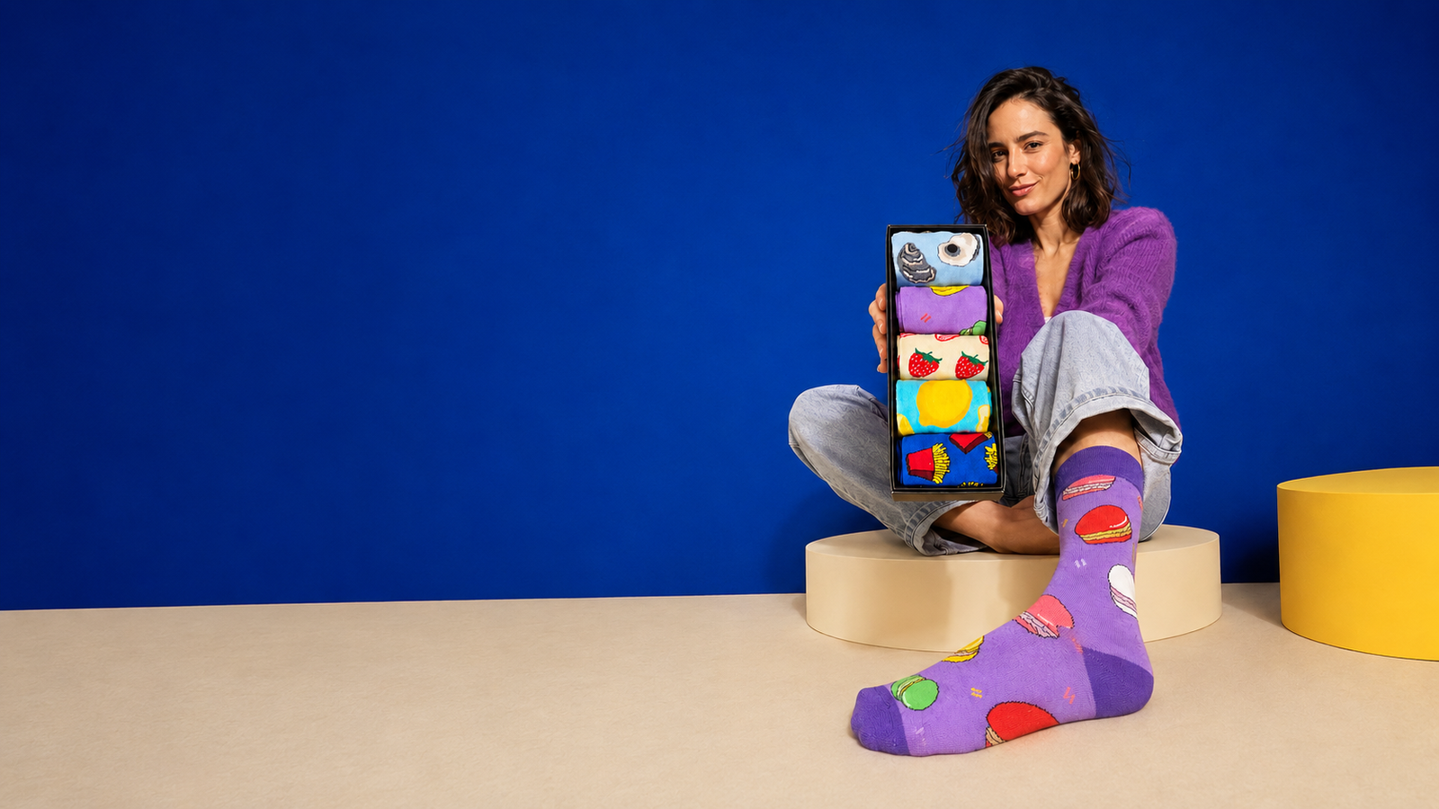 Une femme présente son coffret de cinq paires de chaussettes fantaisie